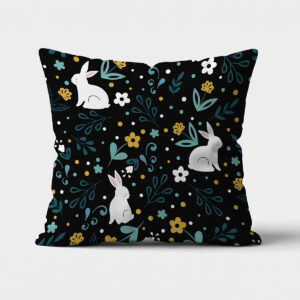 główne ujęcie poduszki z białymi króliczkami na czarnym tle i miętowymi gałązkami