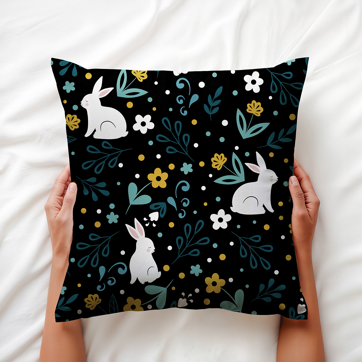widok poduszki trzymanej w dłoniach ukazujący wzór z króliczkami i drobnymi kwiatami