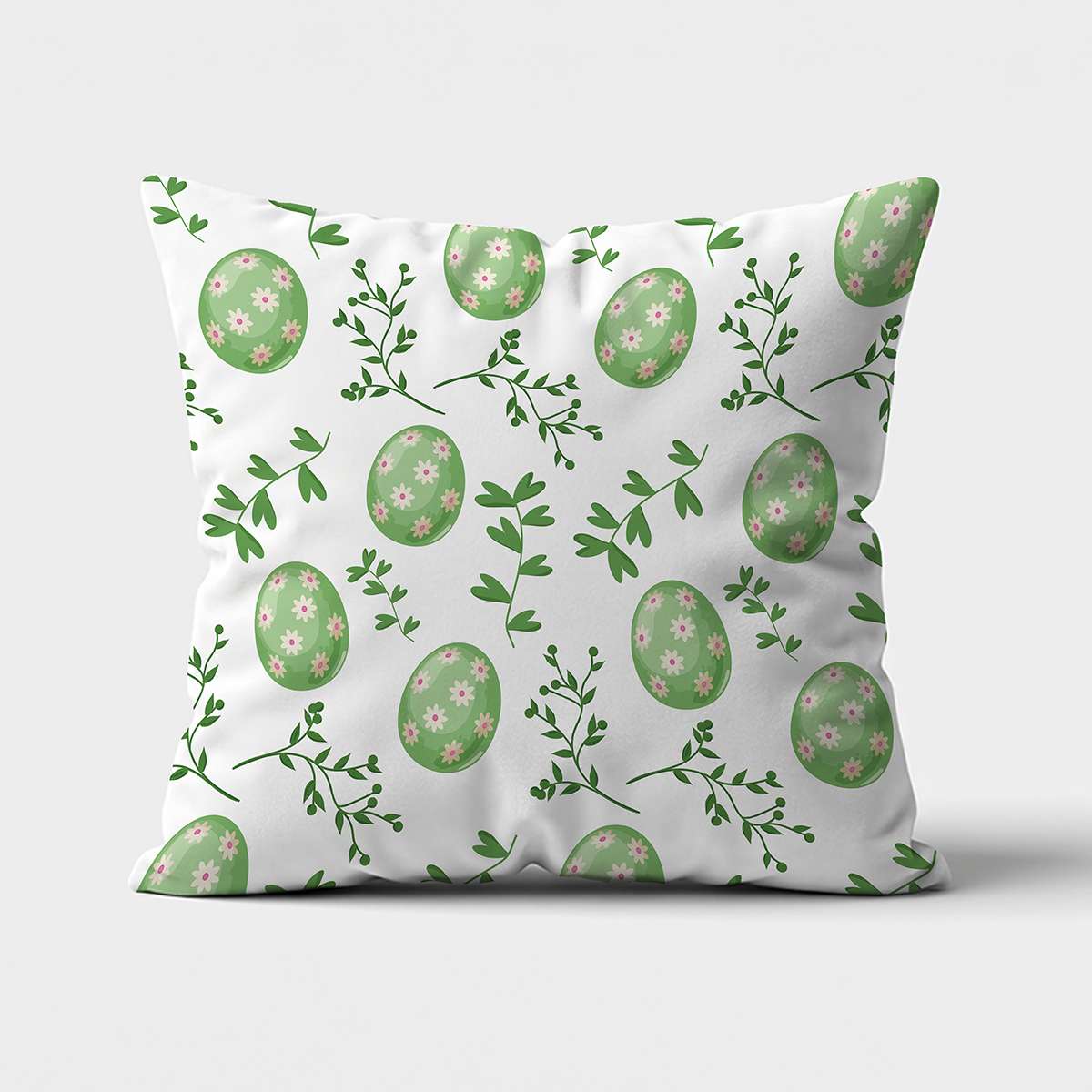 Poduszka z przodu na białym tle z motywem zielonych pisanek i gałązek