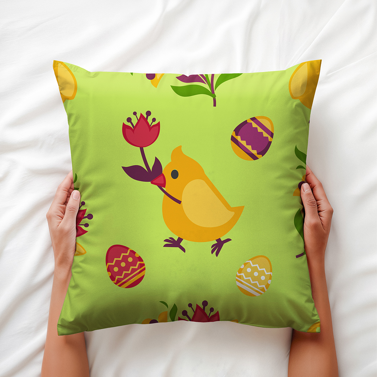 Widok poduszki trzymanej dłońmi, zbliżenie na kurczaka z kwiatem i ozdobne pisanki