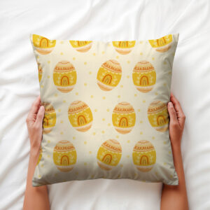 Poduszka trzymana w dłoniach, widok z góry pokazujący wzór pisanek i kropki