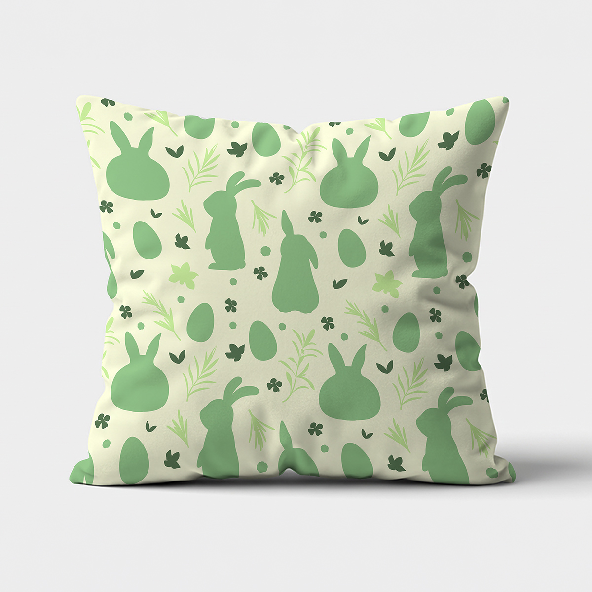 Poduszka z wzorem zielonych zajączków i pisanek na kremowym tle, widok z przodu