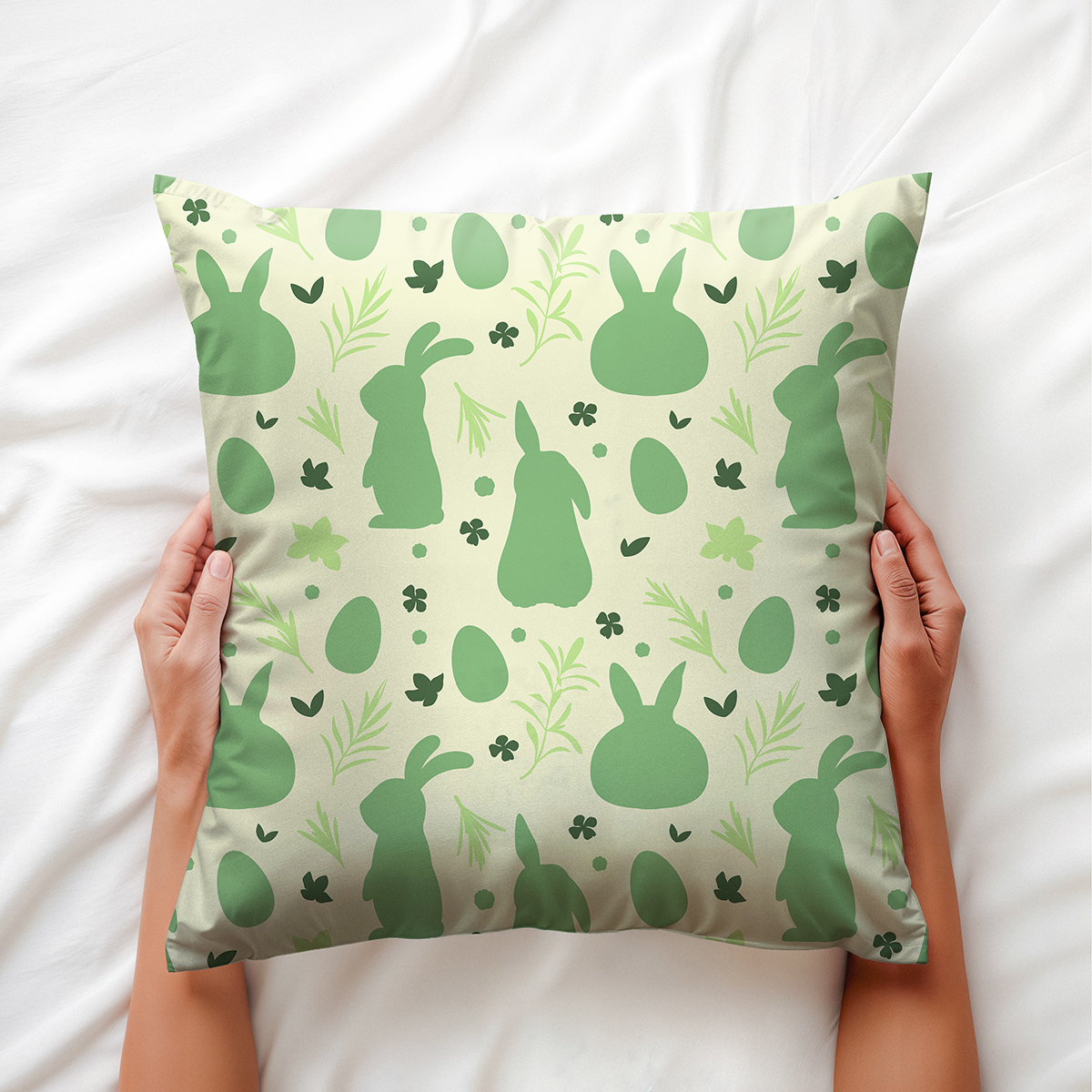 Poduszka trzymana w dłoniach, widok z góry ukazujący powtarzalny wzór z zajączkami