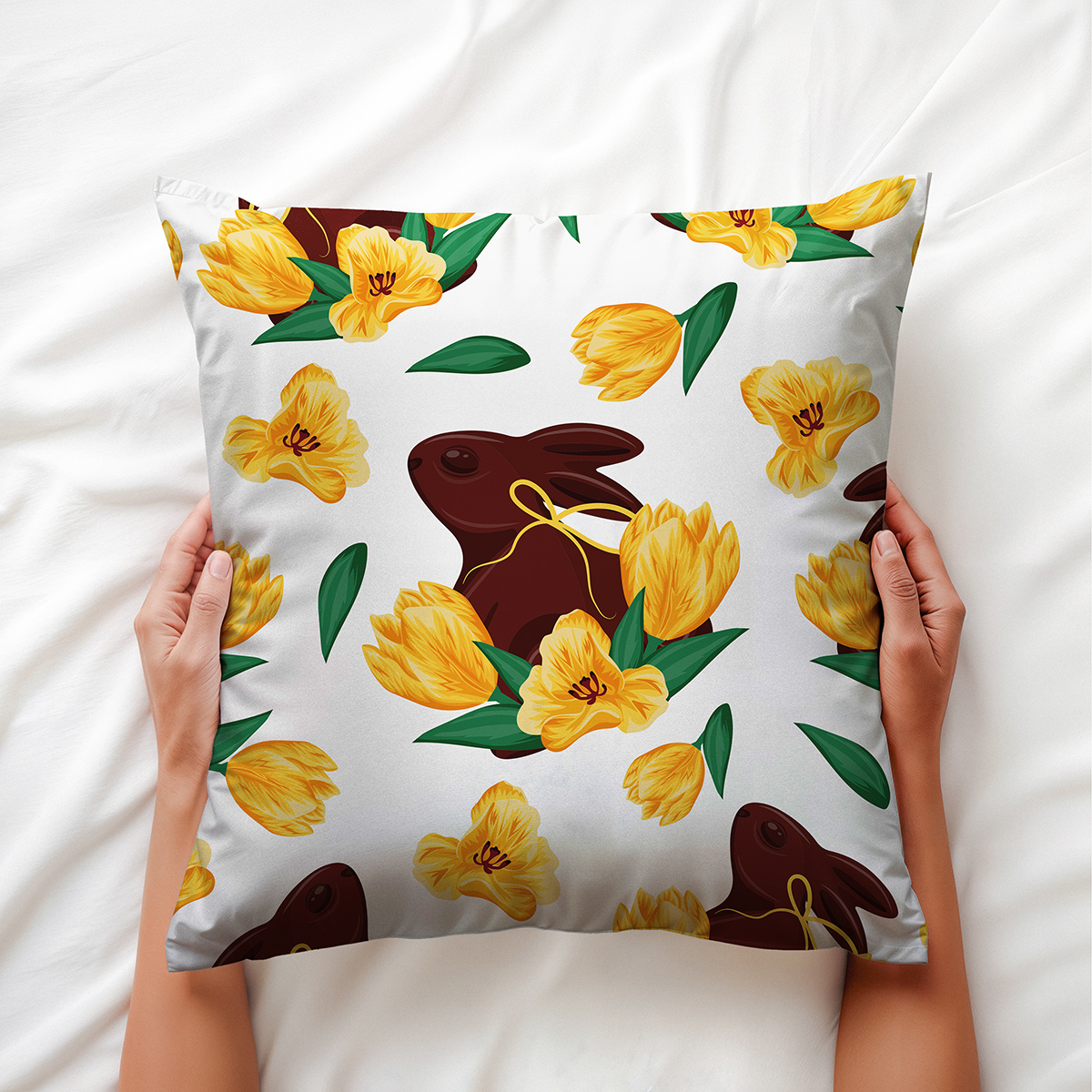Dłoń trzymająca poduszkę z wzorem zająca i tulipanów — ujęcie aranżacyjne