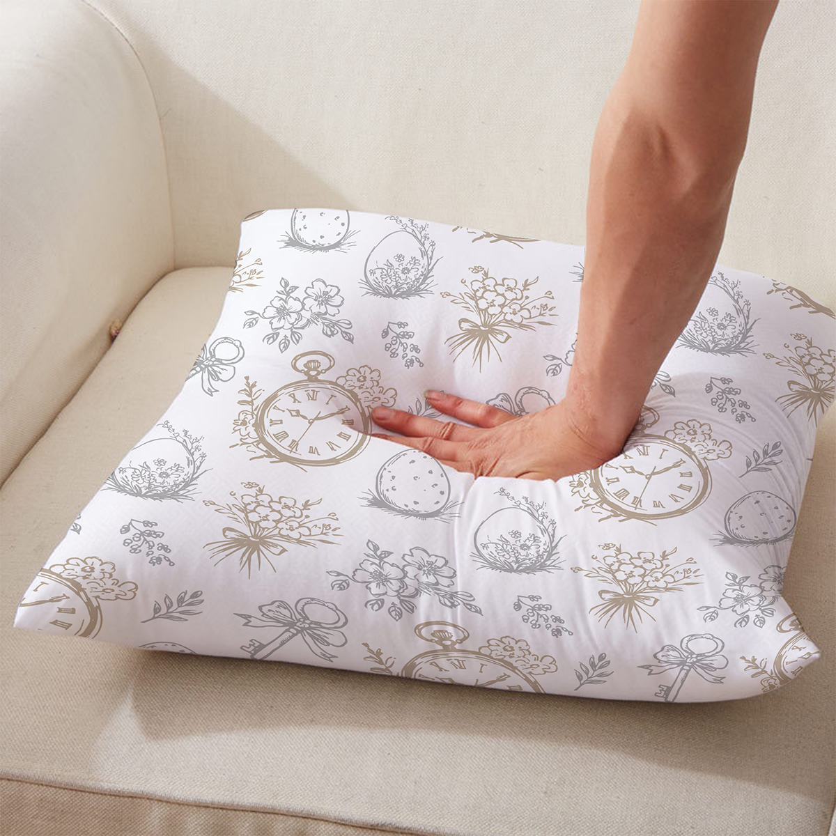 Ręka naciskająca poduszkę, widoczna sprężystość i dekoracyjny motyw z zegarami i kokardkami
