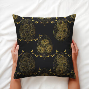 Zbliżenie na poduszkę trzymaną w dłoniach ukazujące złote, kwiatowe ornamenty pisanek