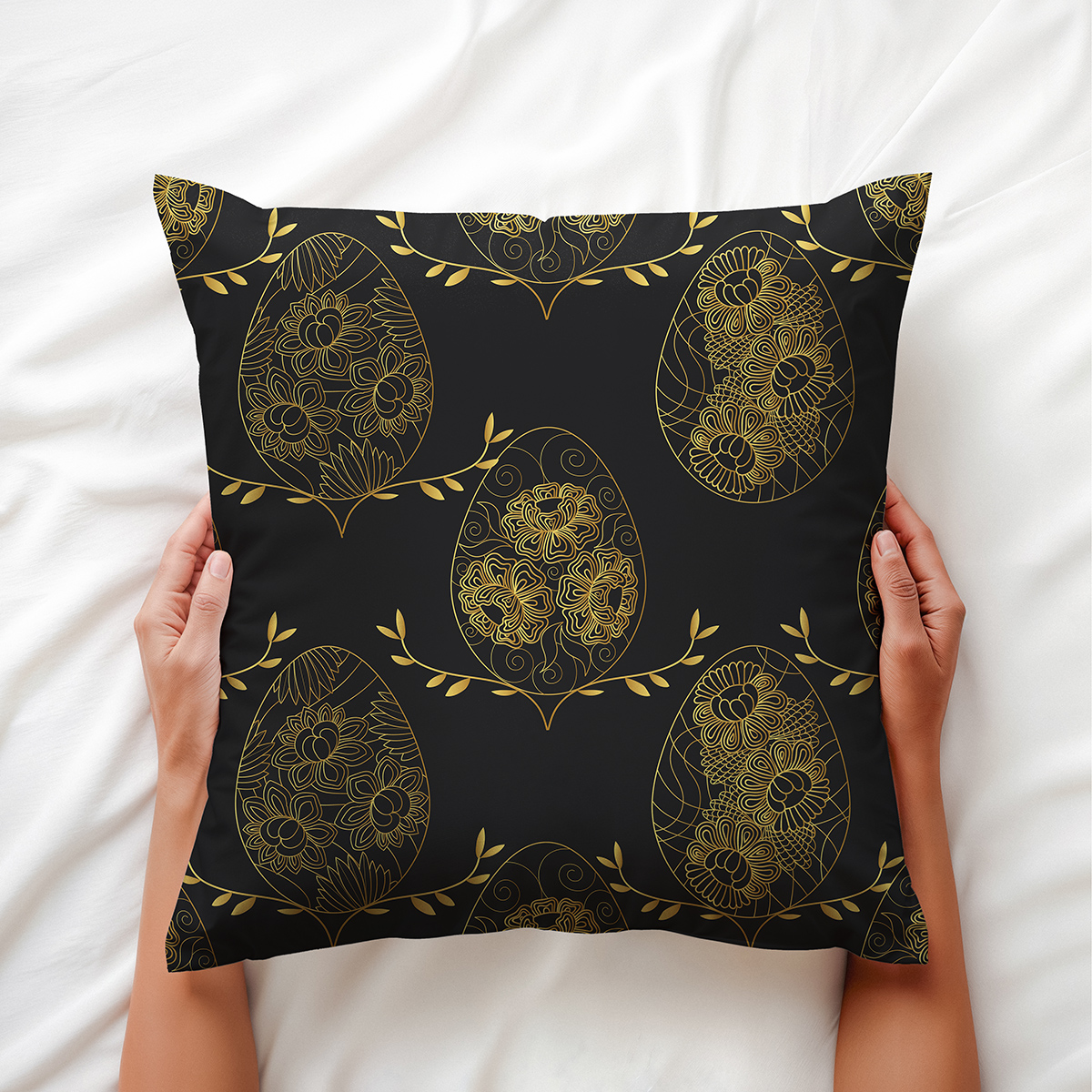 Zbliżenie na poduszkę trzymaną w dłoniach ukazujące złote, kwiatowe ornamenty pisanek