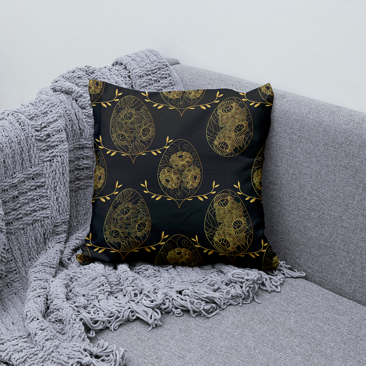 Aranżacja poduszki na kanapie przy szarym kocu pokazująca całe powtarzalne motywy