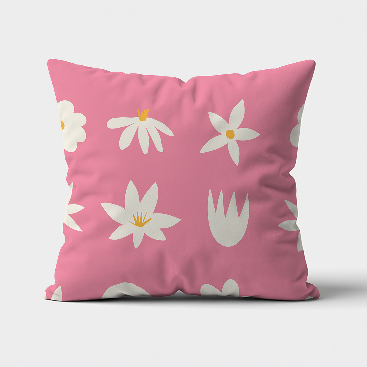 Poduszka z białymi stokrotkami i żółtymi środkami na różowym tle, widok z przodu