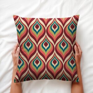 Widok z góry: ręce trzymające poduszkę z geometrycznym wzorem retro, wyraźne kolory i faktura tkaniny