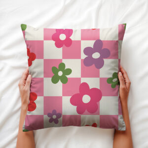Detal poszewki trzymanej w dłoniach, pokazujący wzór kratki i kwiatów