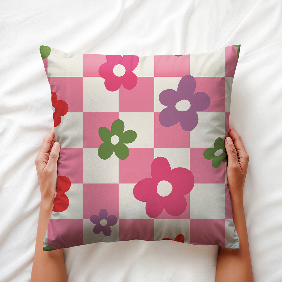 Detal poszewki trzymanej w dłoniach, pokazujący wzór kratki i kwiatów