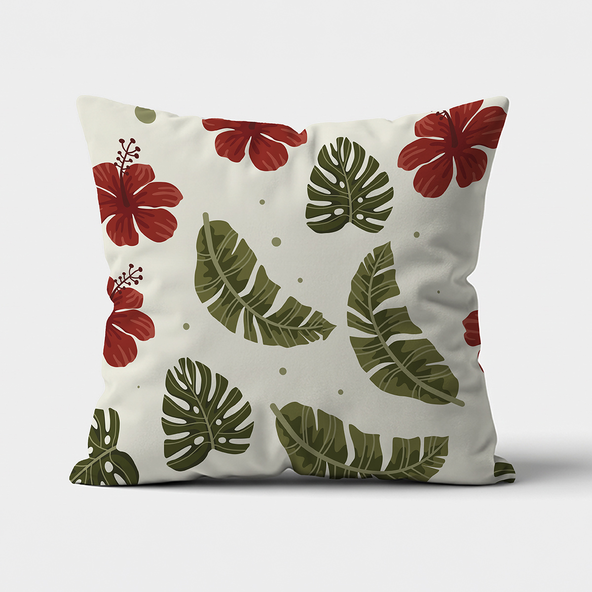 Poduszka dekoracyjna z zielonymi tropikalnymi liśćmi i czerwonymi hibiskusami na kremowym tle, widok z przodu