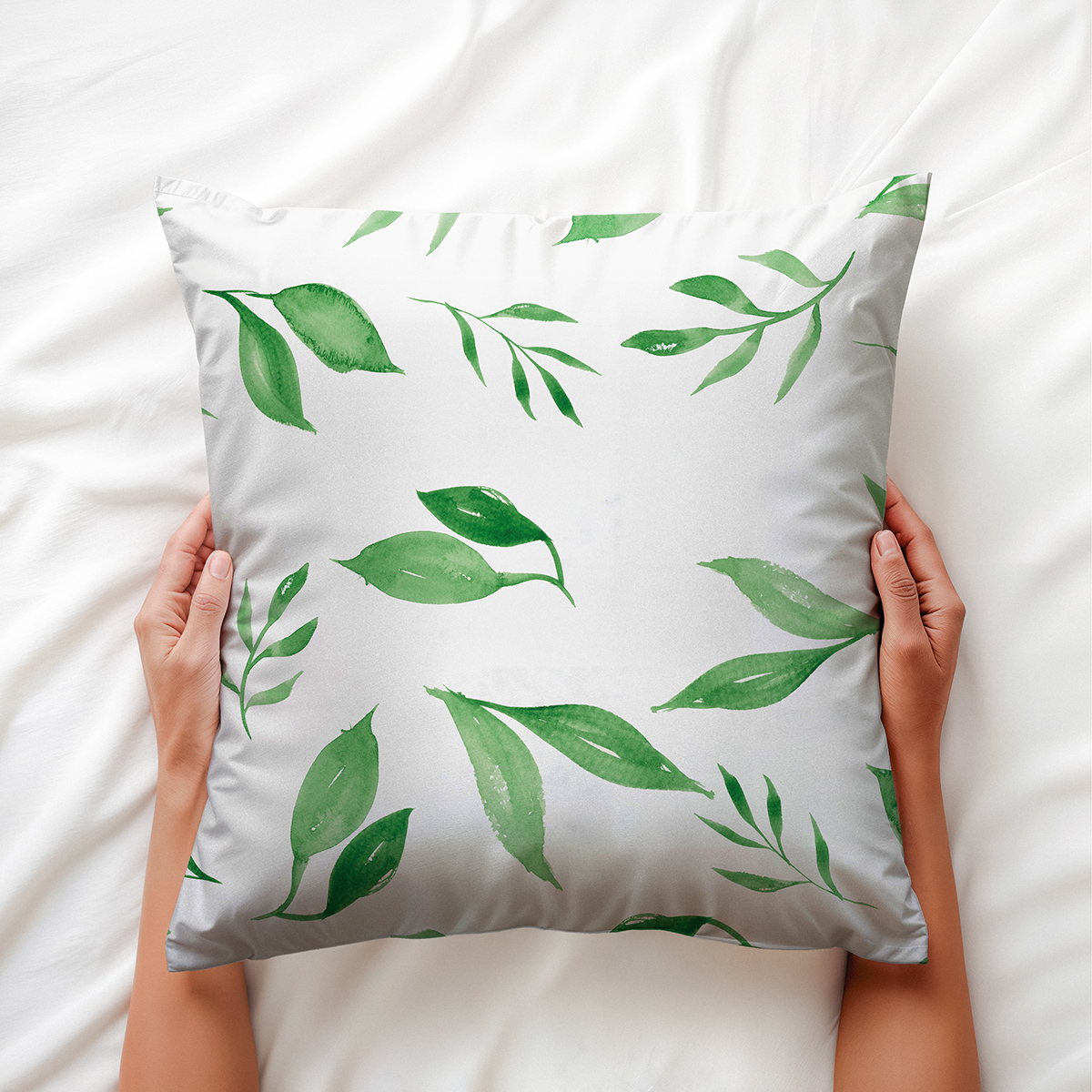 widok z góry, dłonie trzymają miękką poduszkę z motywem liści