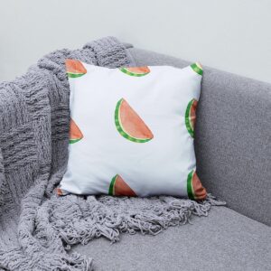 Aranżacja poduszki na sofie z szarym kocem, widoczne powtarzające się plasterki arbuza