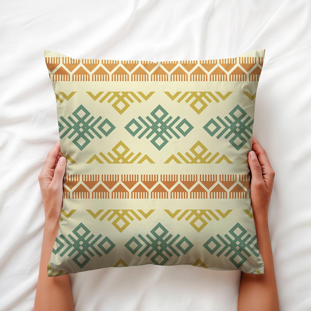 Poduszka trzymana w dłoniach na białej pościeli, widoczny pasy i detal nadruku