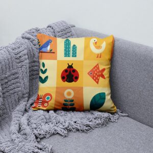Poduszka ułożona na kanapie obok pledu, pokazująca całą kompozycję kolorowych motywów