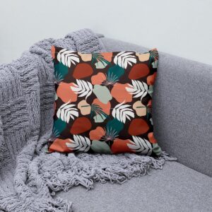 Aranżacja: poduszka dekoracyjna ułożona na kanapie obok pledu, widok z boku