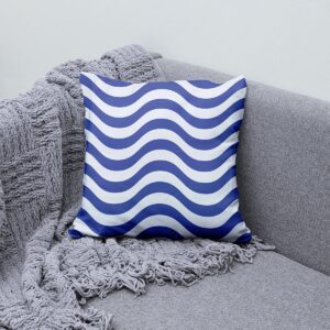 Poduszka z falami ułożona na szarej sofie obok pledu, aranżacyjne ujęcie