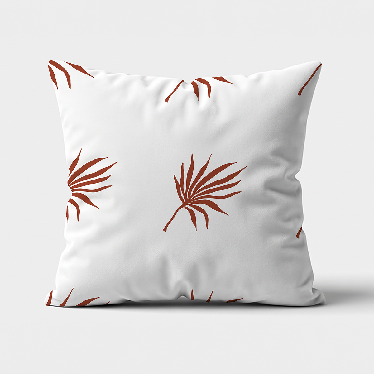 poduszka ozdobna na białym tle z rdzawym motywem palmowych liści — główne ujęcie