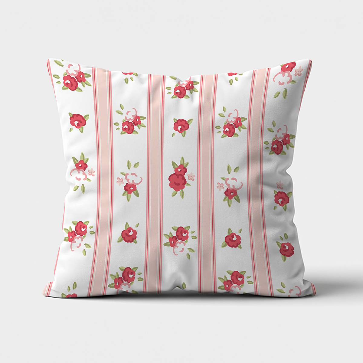 Główne ujęcie poduszki dekoracyjnej z różowymi pionowymi pasami i drobnymi czerwonymi różyczkami na białym tle