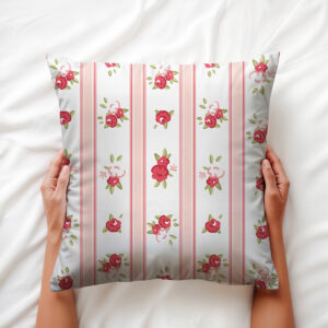 Widok z góry: poduszka trzymana dłońmi na jasnej pościeli, widoczne detale wzoru i kolory