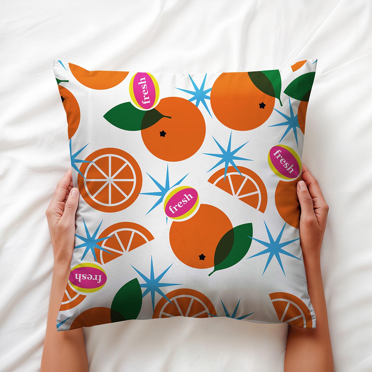 Zbliżenie na nadruk pomarańczy i detal etykiety "fresh" trzymane w dłoniach