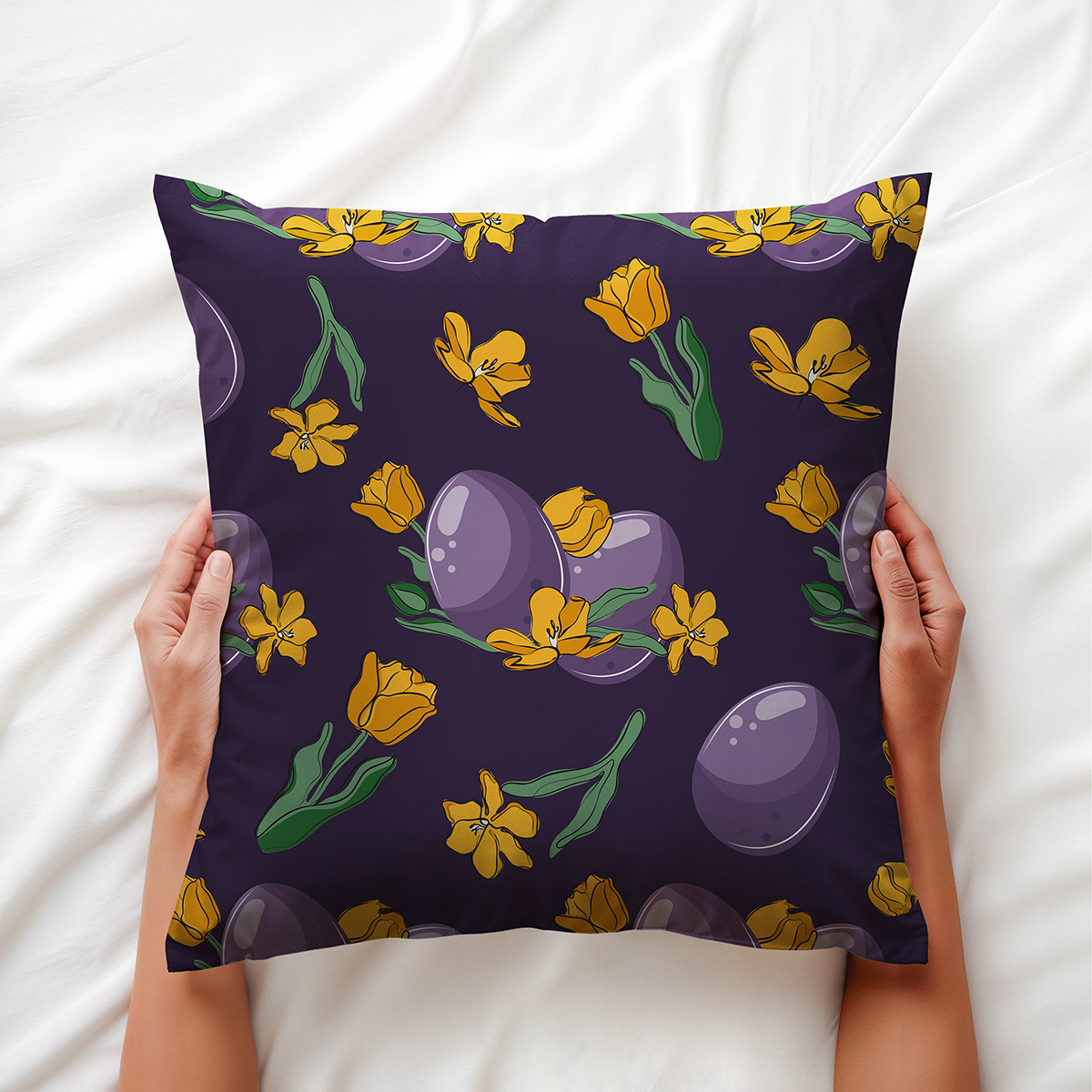 Ręce trzymające poduszkę z detalem wzoru przedstawiającym pisanki i kwiaty