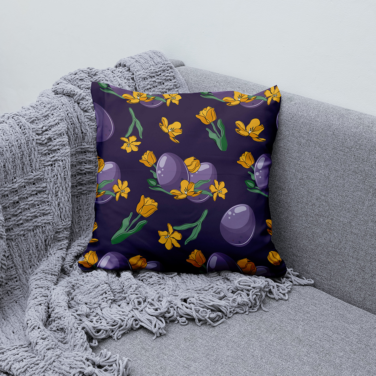 Poduszka ułożona na kanapie obok miękkiego koca jako element aranżacji wnętrza