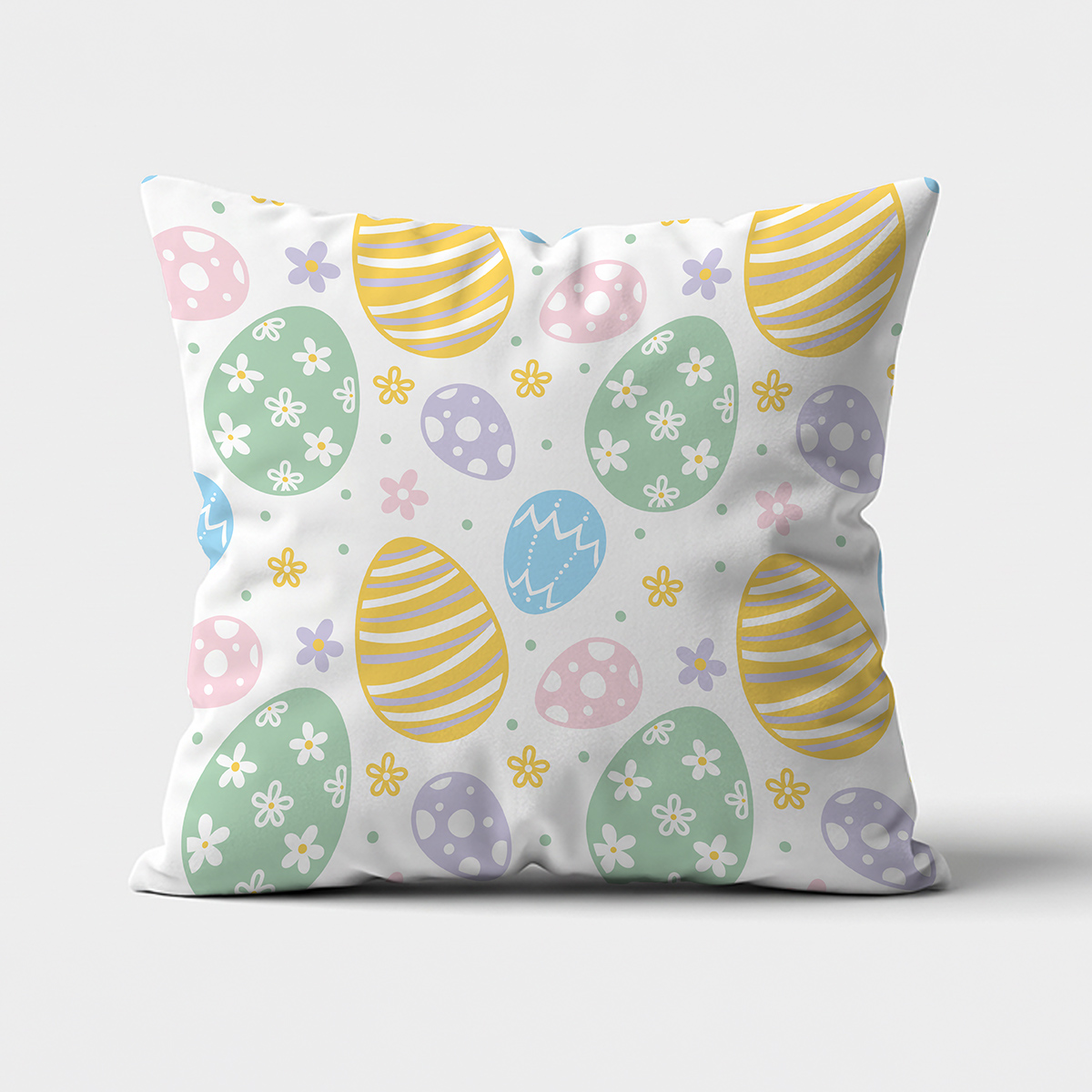 Główne ujęcie poduszki z pastelowymi pisankami i kwiatkami na jasnym tle