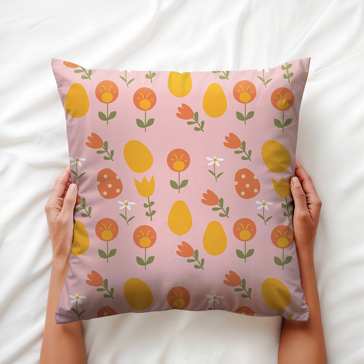 widok poduszki trzymanej w dłoniach, wzór pastelowych pisanek i tulipanów