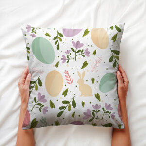 Osoba trzymająca poduszkę z motywem pisanek, zbliżenie dłoni