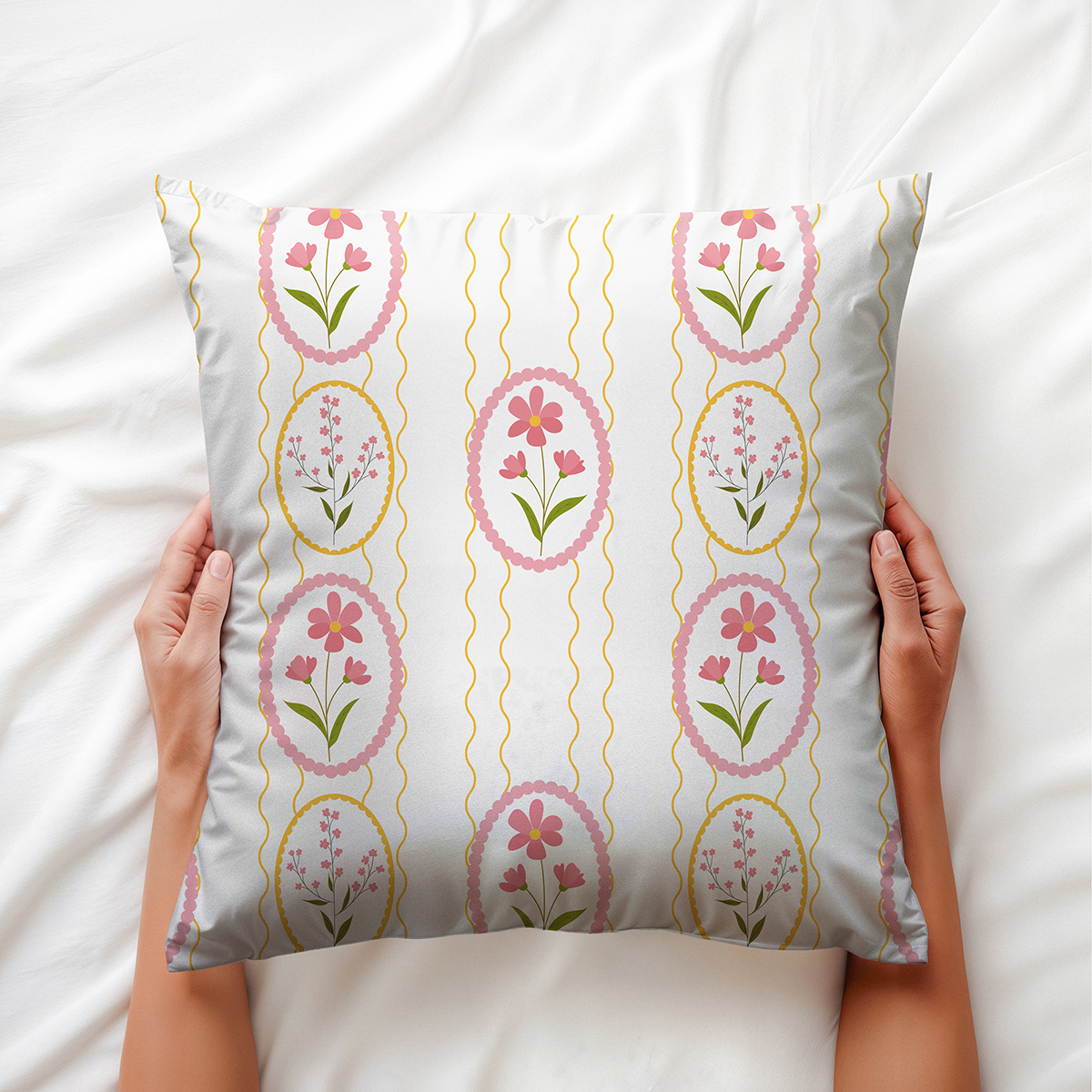 Widok z góry: dłonie trzymają poduszkę z pionowym wzorem pisanek i falistymi żółtymi liniami