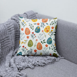 Poduszka ułożona na sofie obok pledu, widoczny całościowy wzór