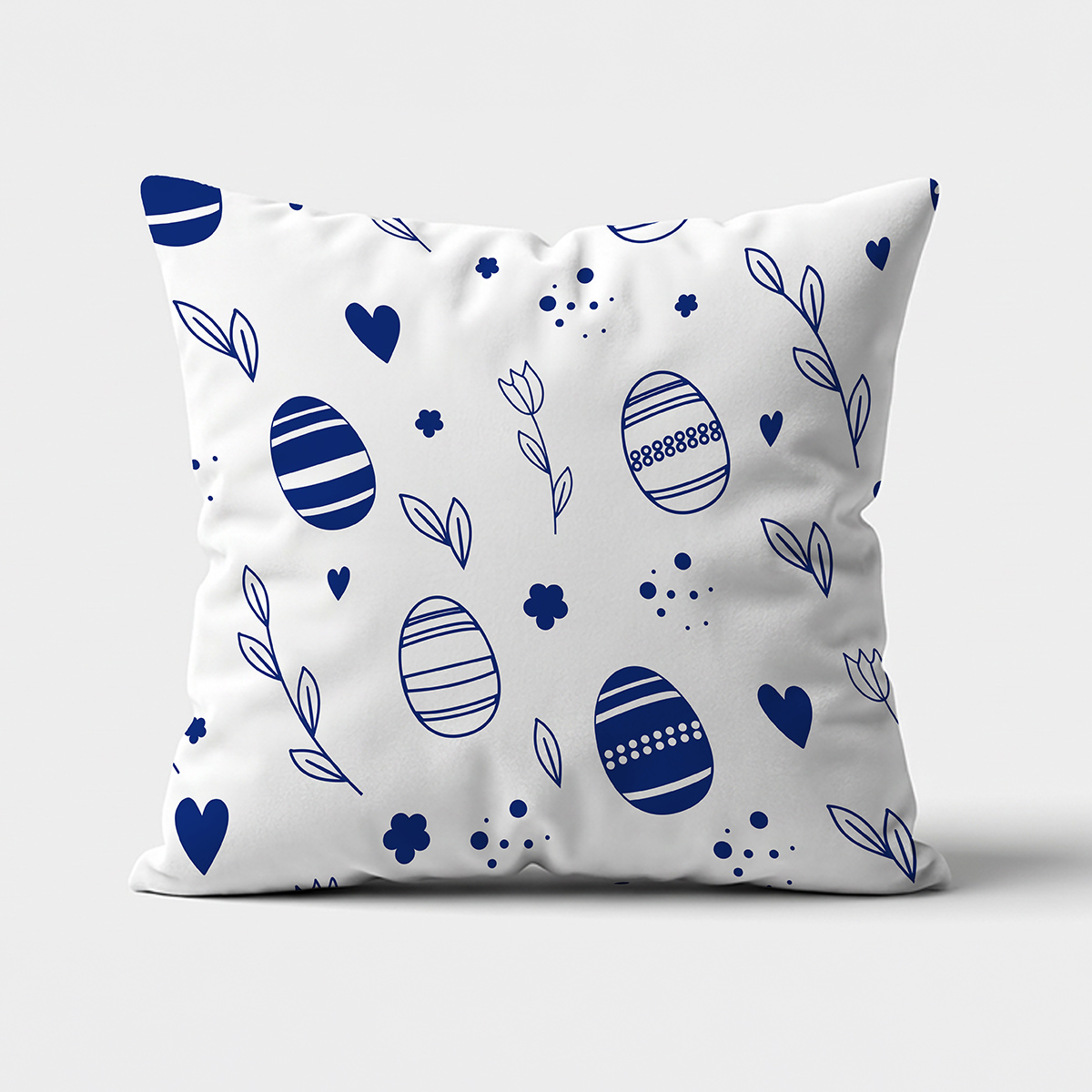 Biała dekoracyjna poduszka z granatowym wzorem pisanek i gałązek na neutralnym tle