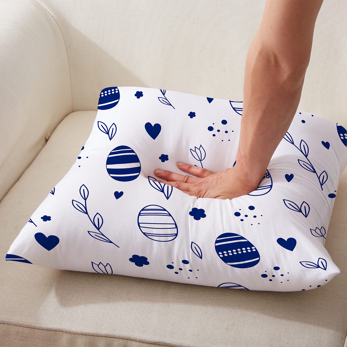 Ręka naciska miękką poduszkę z wiosennym wzorem pisanek i drobnych kropek