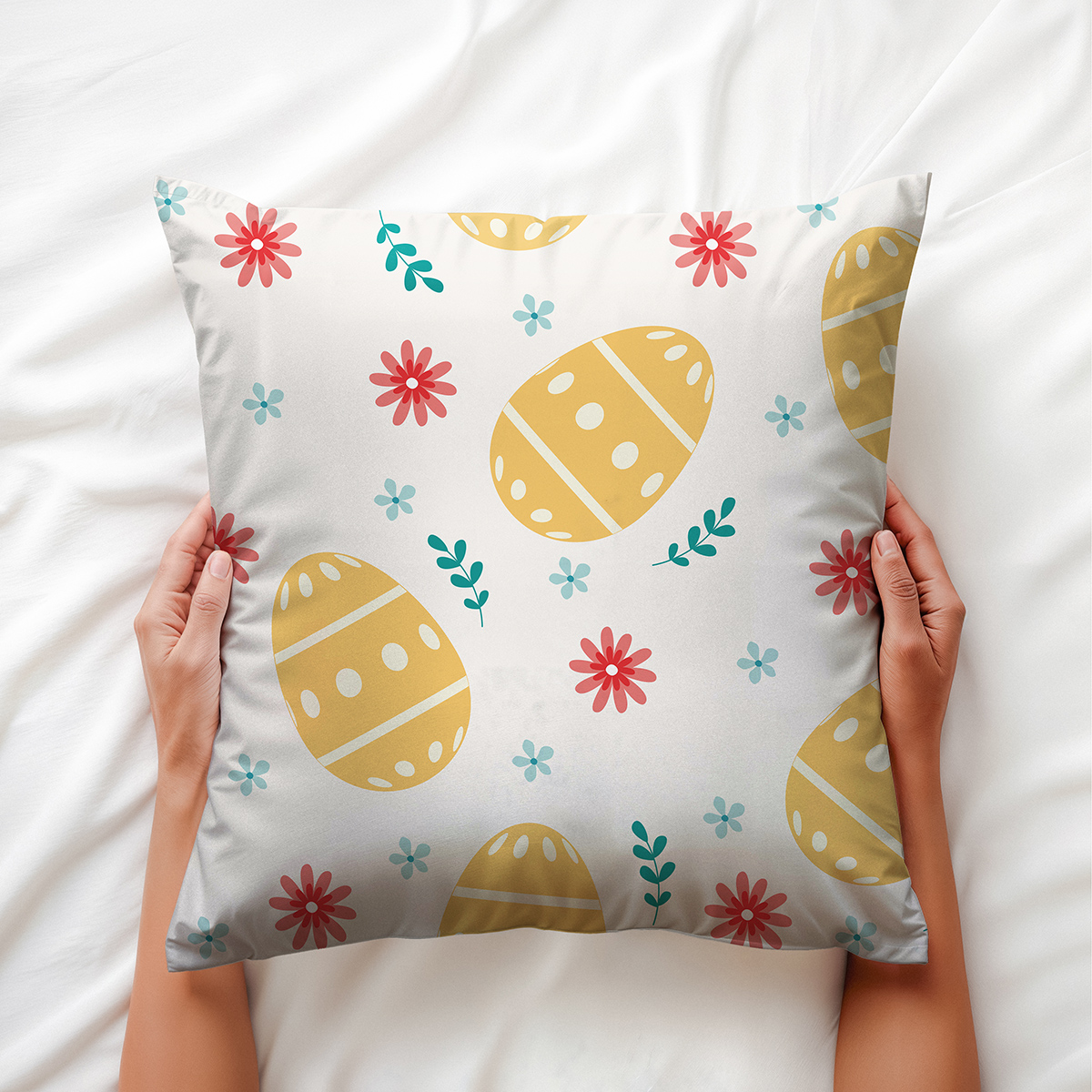 ręce trzymające poduszkę, detal wzoru z jajkami i kwiatami