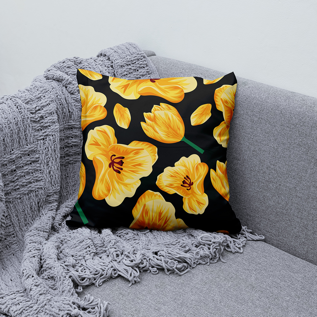 Poduszka ułożona na kanapie obok pledu, aranżacja wnętrza