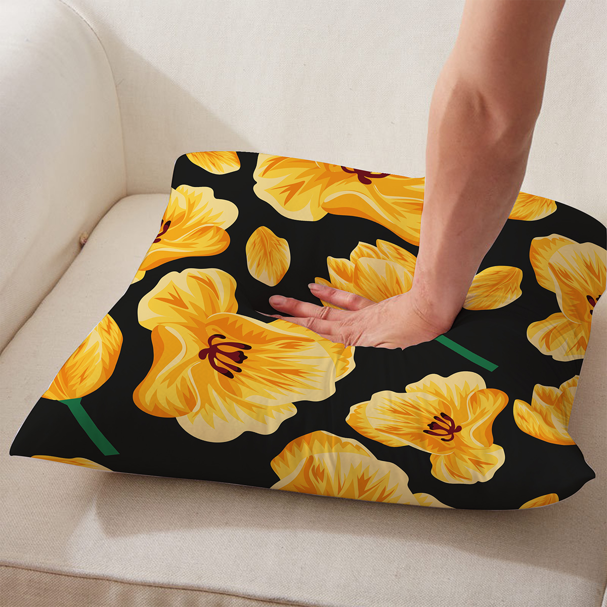 Ręka naciskająca miękką poduszkę z żółtymi tulipanami