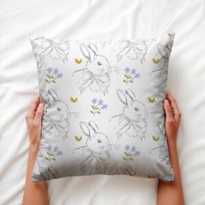 Poduszka wielkanocna z wzorem w króliczki trzymana w rękach