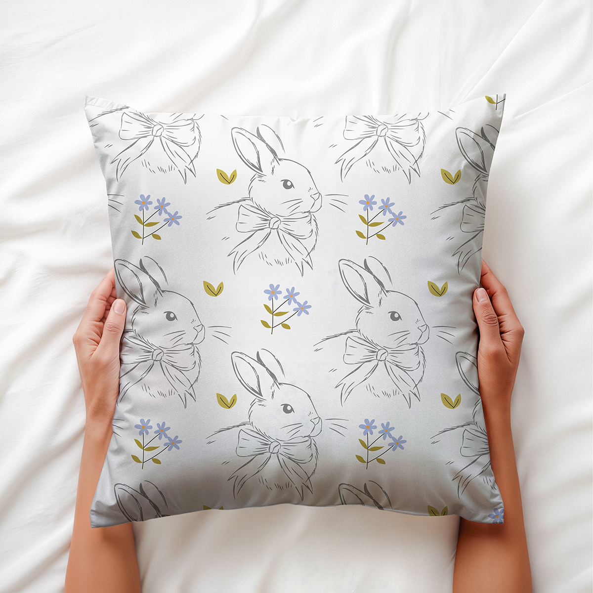 Poduszka wielkanocna z wzorem w króliczki trzymana w rękach