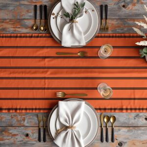 Aranżacja stołu z bieżnikiem w ceglastym odcieniu i zastawą w neutralnych kolorach