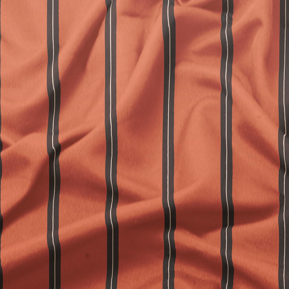 detal tkaniny pokazujący pionowe brązowe paski na ceglastym tle