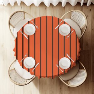 widok z góry na stół nakryty obrusem w ceglaste paski z brązowymi akcentami i ustawioną zastawą