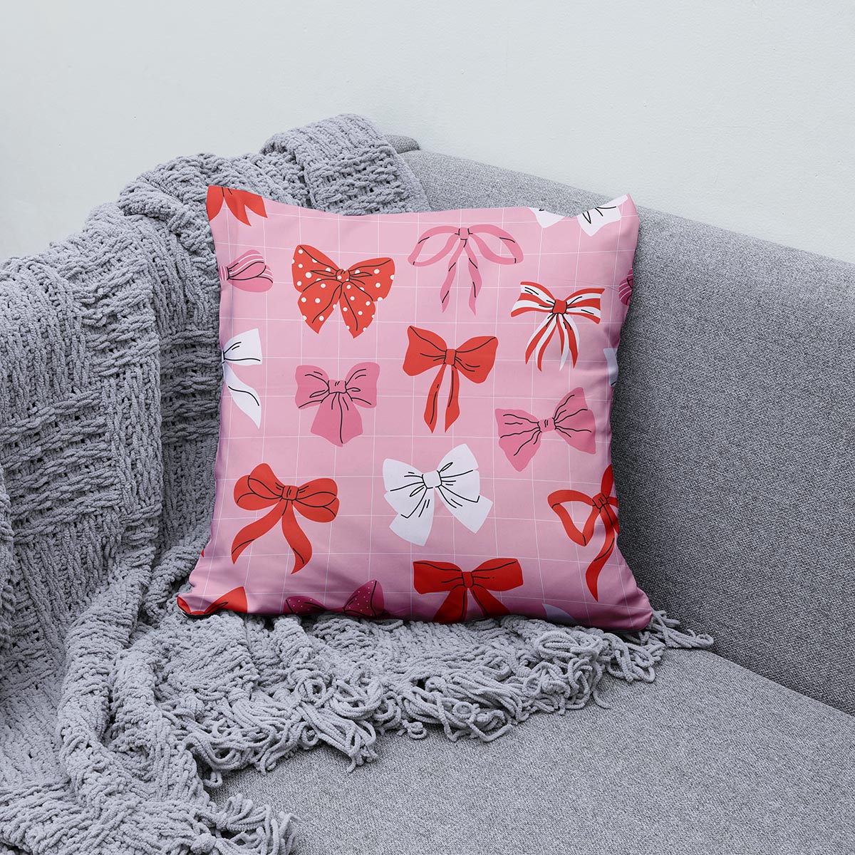 Poduszka ułożona na sofie obok pledu, aranżacja wnętrza