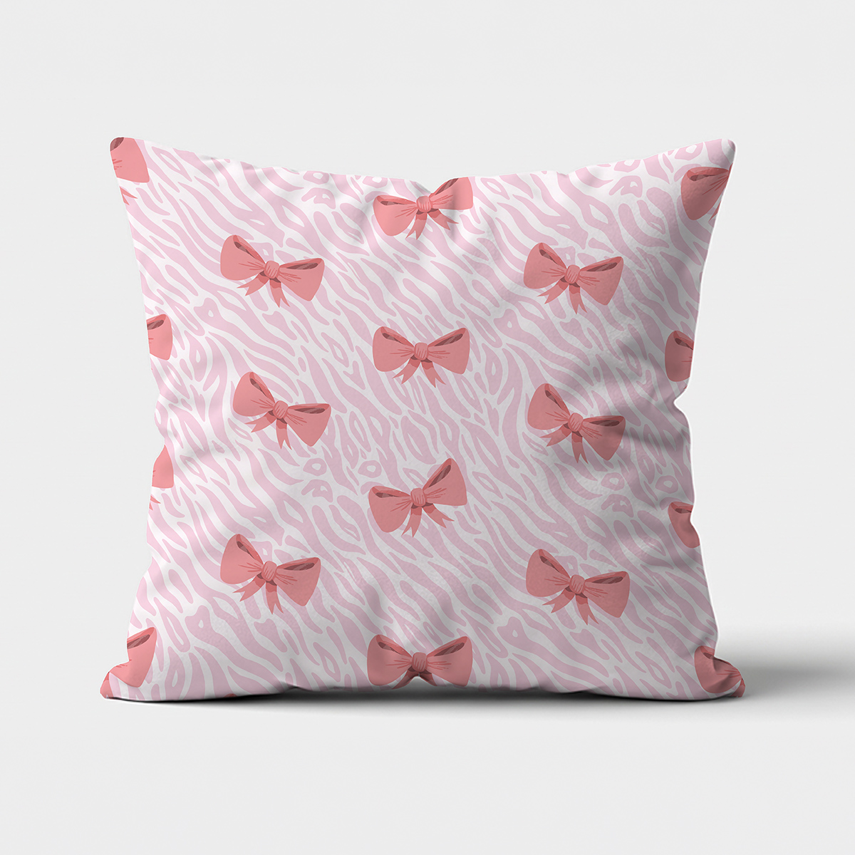 frontowe ujęcie poduszki ozdobnej z różowymi kokardkami na delikatnym tle