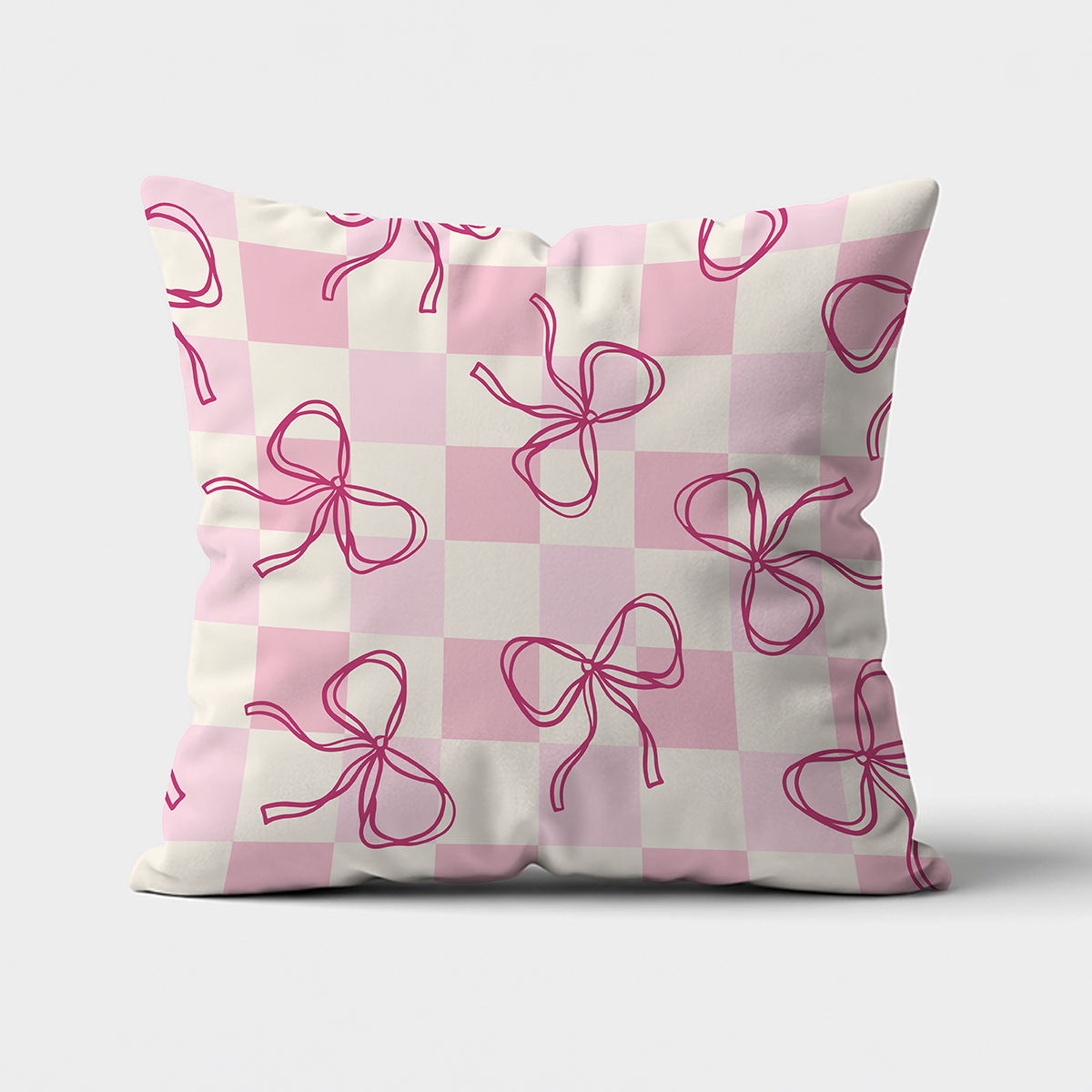 poduszka z przodu na jasnym tle, pudrowa kratka z odręcznymi różowymi kokardkami