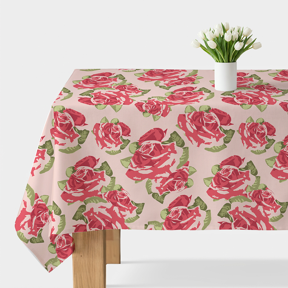 Obrus rozłożony na stole z dużymi malowanymi różami na pudrowym tle