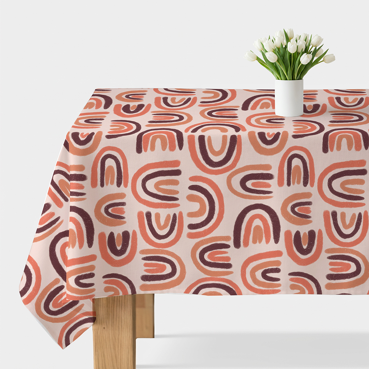 Główne ujęcie obrusu z motywem malowanych łuków i białym wazonem z tulipanami