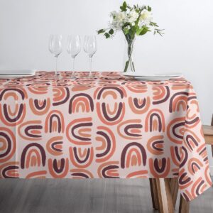 Ujęcie stołu ze szkłem i zastawą na obrusie w odcieniach koralu i bordo